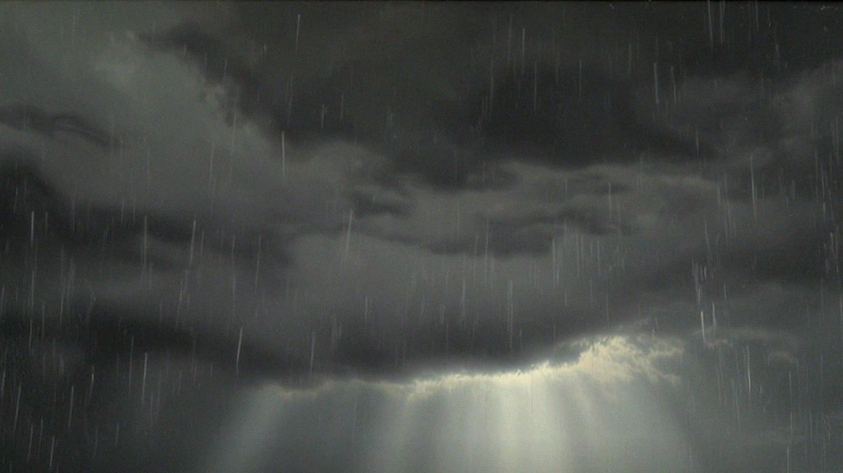 Light breaking through storm clouds over the water